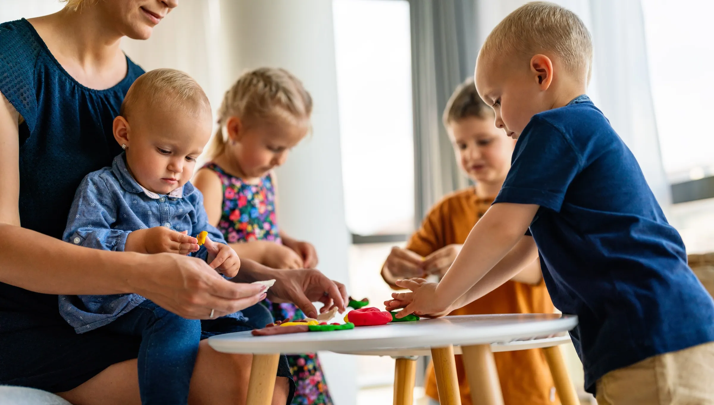 A bright Parisian crèche playroom with toddlers and colourful toys