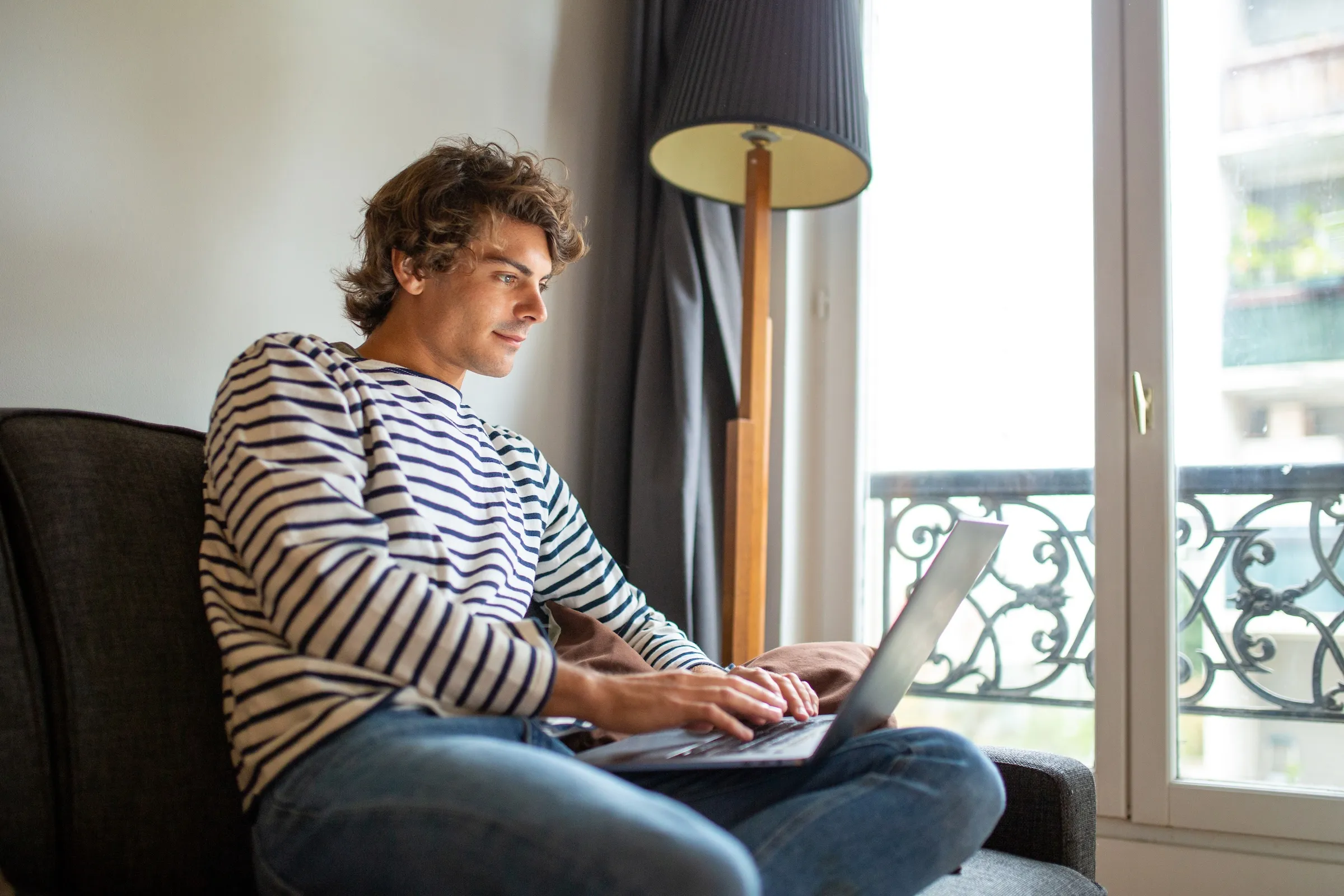 An expat completing the online VLS-TS validation on a laptop in a Parisian apartment